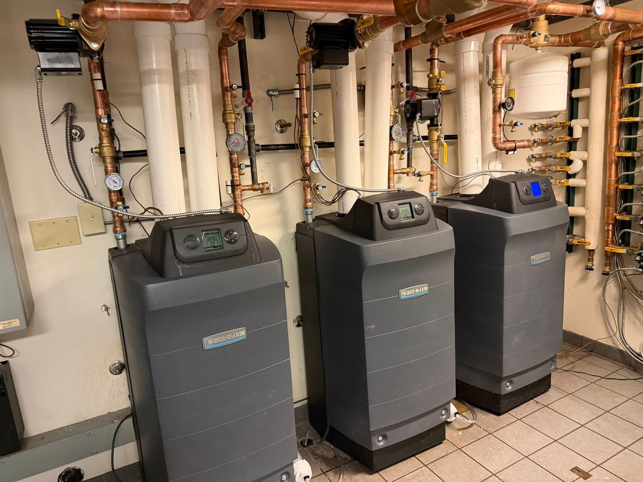 Bank of high-efficiency boilers and copper hydronic piping by NBL Construction
