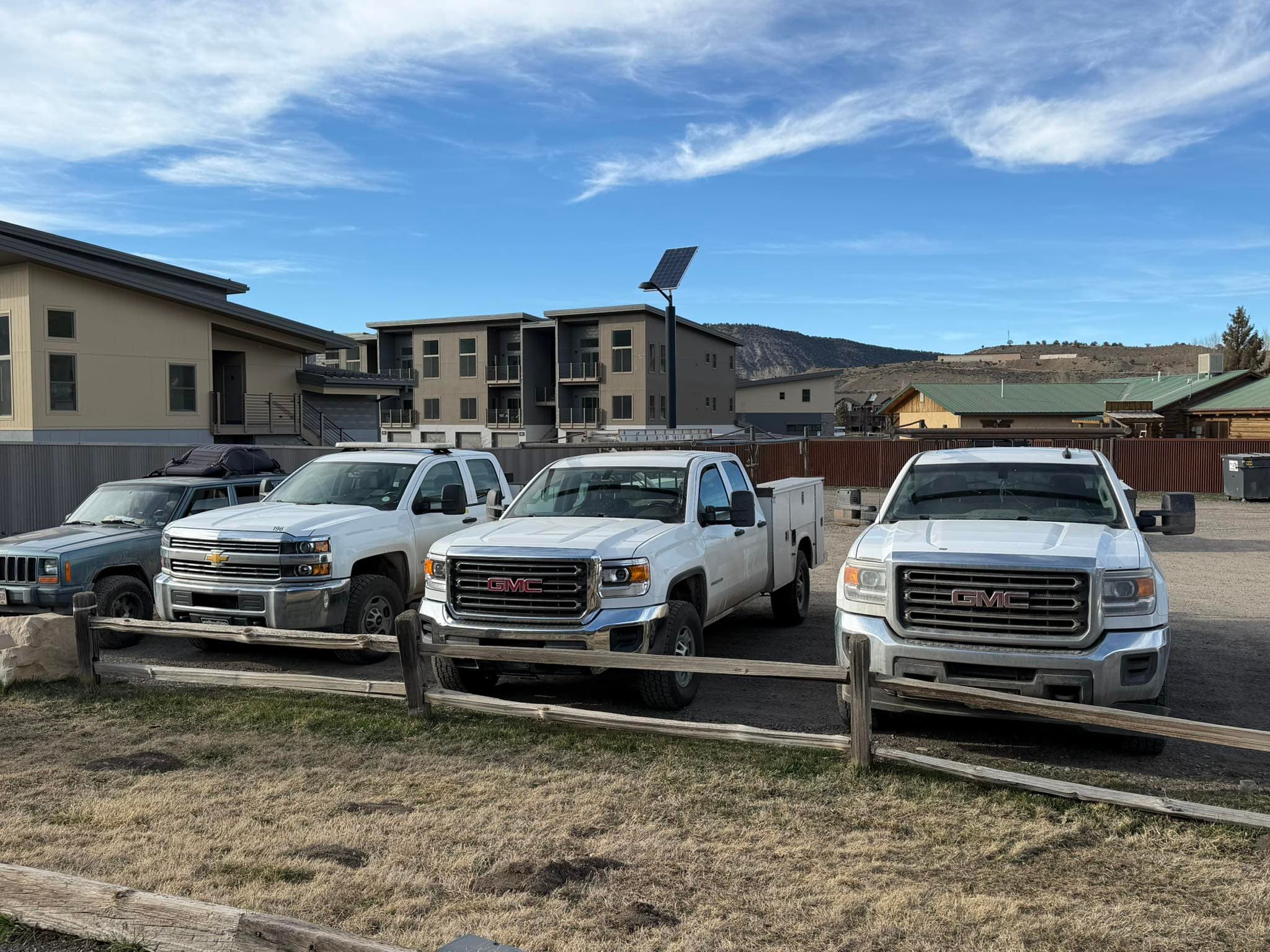 NBL Construction service trucks parked in front of a multifamily building