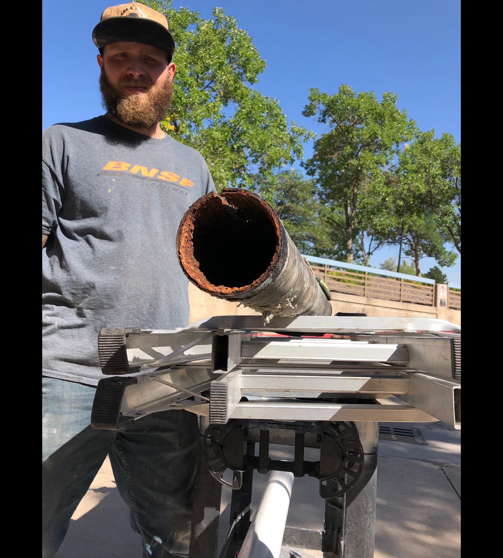 Nick Velasquez holding a corroded section of failed sewer pipe